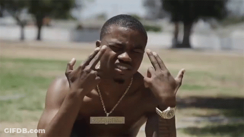 A Shirtless Man Wearing A Watch And A Necklace With A Pendant That Says ' Aboogy.com ' GIF