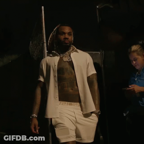 A Shirtless Man Wearing A White Shirt With A Greek Key Pattern On The Sleeves GIF