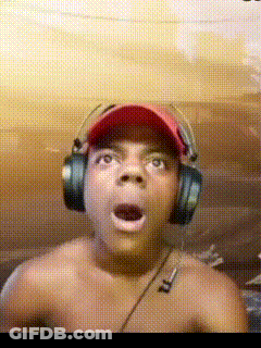 A Shirtless Man Wearing Headphones And A Baseball Cap Looks Surprised GIF