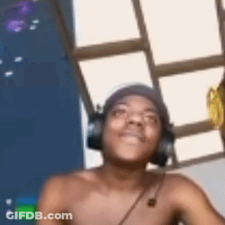 A Shirtless Man Wearing Headphones And A Beanie Is Smiling . GIF