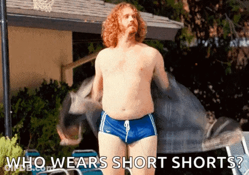 A Shirtless Man Wearing Short Shorts Is Standing Next To A Pool With The Words Who Wears Short Shorts . GIF