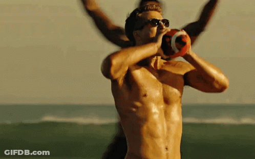 A Shirtless Man Wearing Sunglasses Is Holding A Football In His Hands GIF