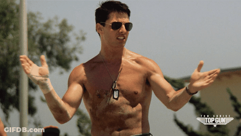 A Shirtless Man Wearing Sunglasses Stands In Front Of A Poster For Top Gun GIF