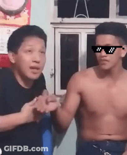 A Shirtless Man Wearing Sunglasses Talks To Another Man GIF