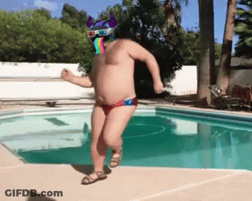 A Shirtless Man With A 3D Helmet On His Head Is Dancing By A Pool GIF