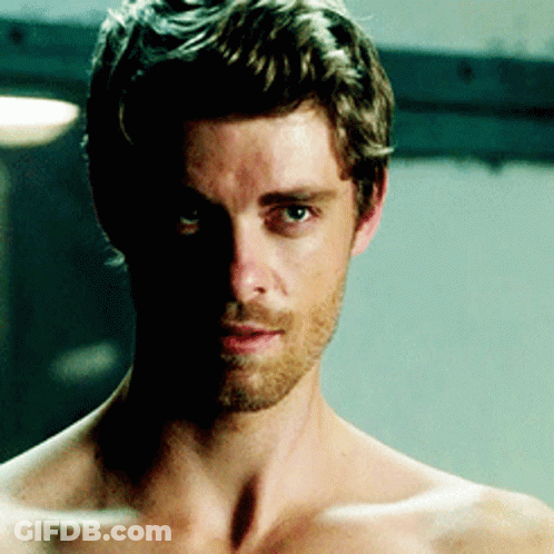 A Shirtless Man With A Beard And A Shadow On His Face GIF