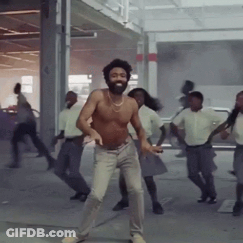 A Shirtless Man With A Beard Is Dancing In A Group Of People GIF