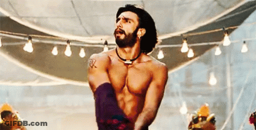 A Shirtless Man With A Beard Is Dancing In A Room With A Lot Of Lights . GIF