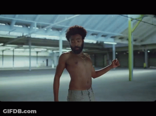 A Shirtless Man With A Beard Is Dancing In An Empty Room GIF