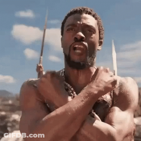 A Shirtless Man With A Beard Is Holding A Spear In His Hand And Making A Funny Face . GIF