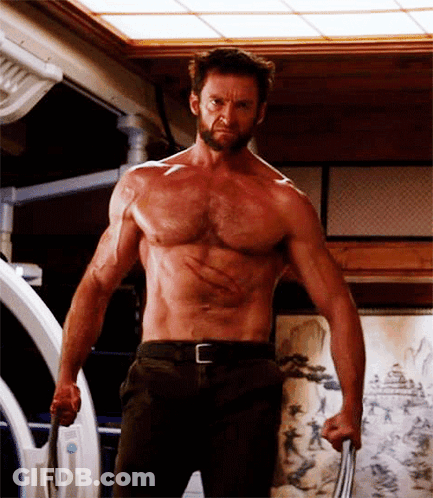 A Shirtless Man With A Beard Is Holding A Sword . GIF