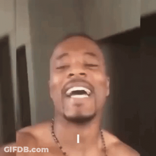 A Shirtless Man With A Beard Is Laughing With His Eyes Closed And His Mouth Open . GIF