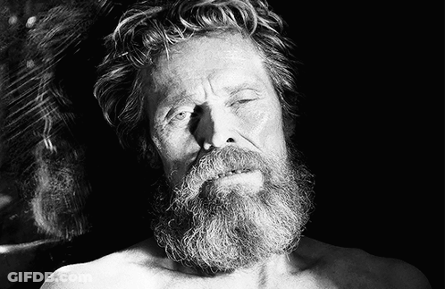 A Shirtless Man With A Beard Is Laying Down With His Eyes Closed GIF