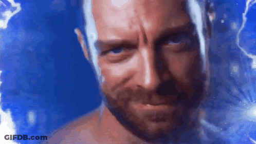 A Shirtless Man With A Beard Is Looking At The Camera With A Blue Background Behind Him . GIF