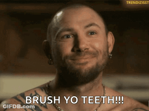 A Shirtless Man With A Beard Is Smiling And Says Brush Yo Teeth GIF