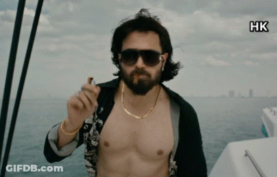 A Shirtless Man With A Beard Is Smoking A Cigarette On A Boat GIF
