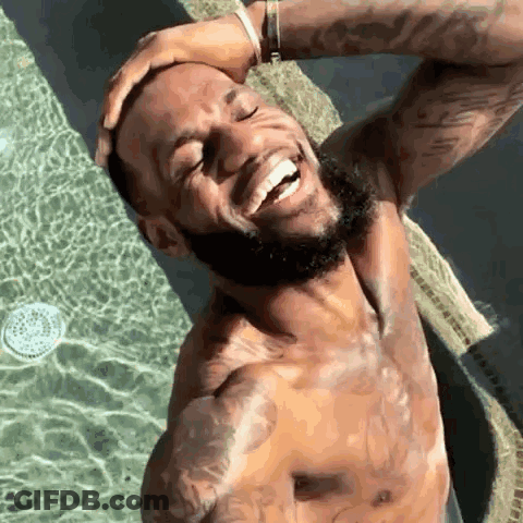 A Shirtless Man With A Beard Is Standing In A Swimming Pool . GIF