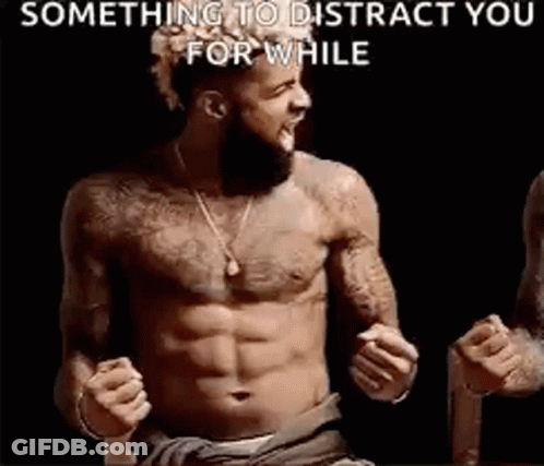 A Shirtless Man With A Beard Is Standing In Front Of A Black Background With His Fist In The Air . GIF