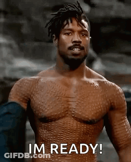 A Shirtless Man With A Beard Is Standing In Front Of A Rock And Says `` Im Ready '' . GIF