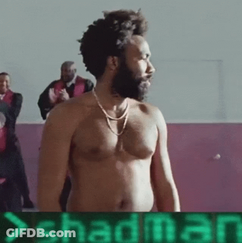 A Shirtless Man With A Beard Is Standing In Front Of A Sign That Says Shadman .. GIF