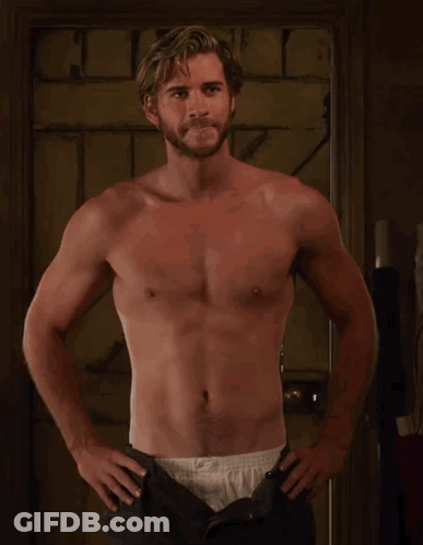 A Shirtless Man With A Beard Is Standing With His Hands On His Hips . GIF