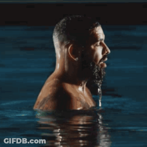 A Shirtless Man With A Beard Is Swimming In A Pool . GIF
