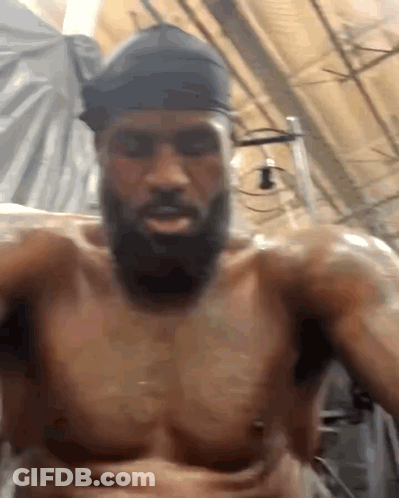A Shirtless Man With A Beard Is Taking A Selfie GIF