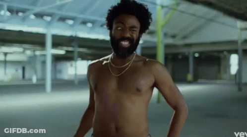 A Shirtless Man With A Beard Is Wearing A Gold Chain Around His Neck And Smiling . GIF