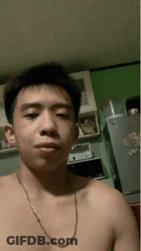 A Shirtless Man With A Chain Around His Neck Is Taking A Selfie GIF