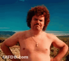 A Shirtless Man With A Cross Necklace On His Neck Stands With His Hands On His Hips GIF