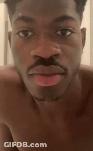 A Shirtless Man With A Mustache Is Making A Funny Face With His Tongue Sticking Out . GIF