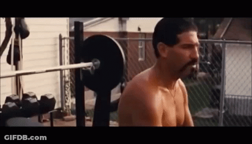 A Shirtless Man With A Mustache Is Squatting On A Bench With A Barbell . GIF