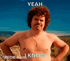 A Shirtless Man With A Mustache Is Standing In A Field With His Hands On His Hips And Says Yeah I Know . GIF