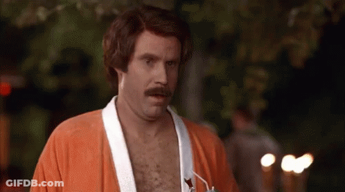 A Shirtless Man With A Mustache Is Wearing An Orange Robe . GIF