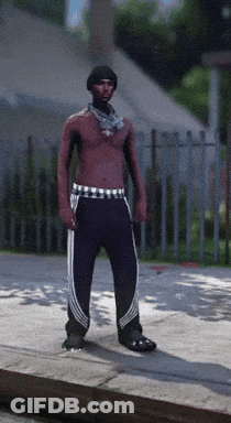 A Shirtless Man With A Scarf Around His Neck Is Standing On The Sidewalk GIF