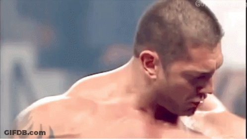 A Shirtless Man With A Tattoo On His Arm Is Standing In A Ring . GIF