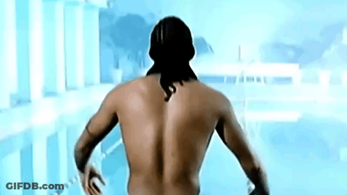 A Shirtless Man With A Tattoo On His Back Is Standing In Front Of A Swimming Pool GIF