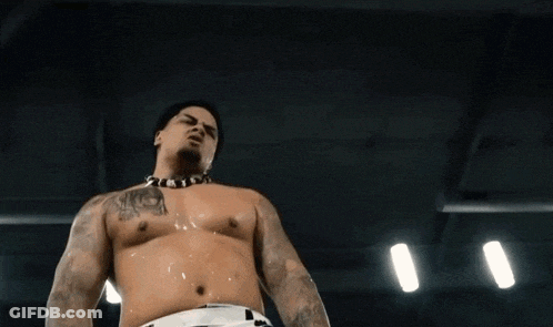 A Shirtless Man With A Tattoo On His Chest Holds His Hand Out GIF