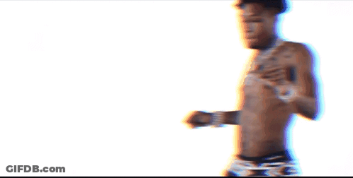 A Shirtless Man With A Tattoo On His Chest Is Wearing Black Underwear GIF