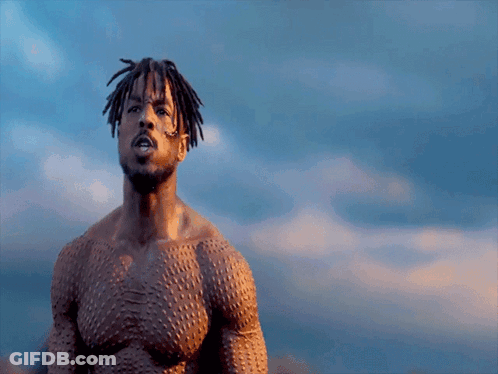 A Shirtless Man With Dreadlocks Stands In Front Of A Blue Sky GIF