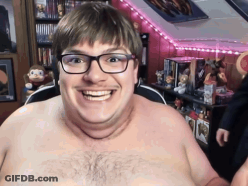 A Shirtless Man With Glasses Is Smiling In A Room GIF