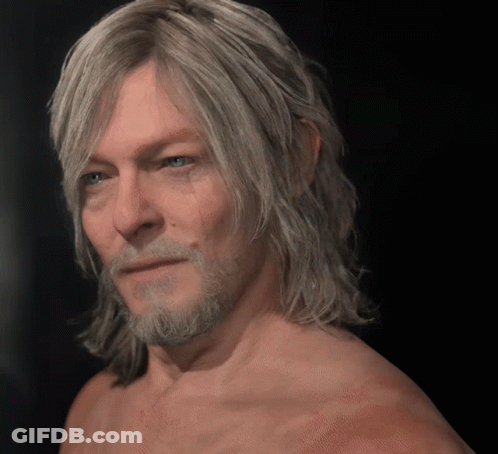 A Shirtless Man With Long Blonde Hair And A Beard Looks At The Camera GIF