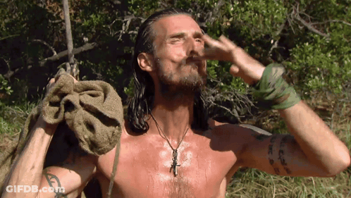 A Shirtless Man With Long Hair Is Holding A Towel Over His Head GIF