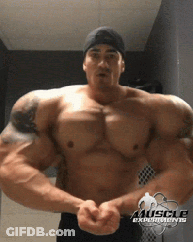 A Shirtless Man With Muscle Experiments In The Corner GIF