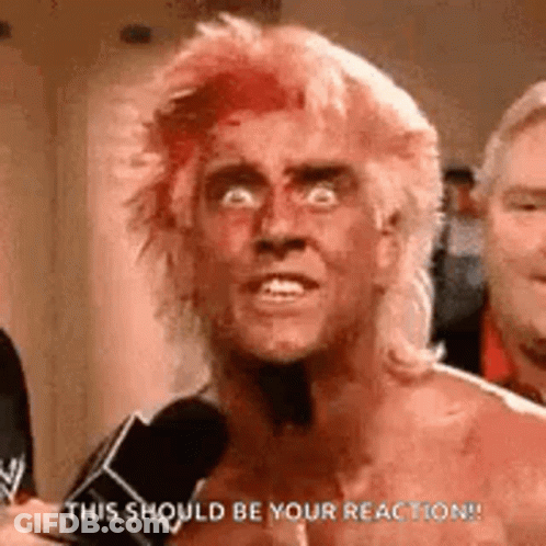 A Shirtless Man With Red Hair Is Talking Into A Microphone . GIF