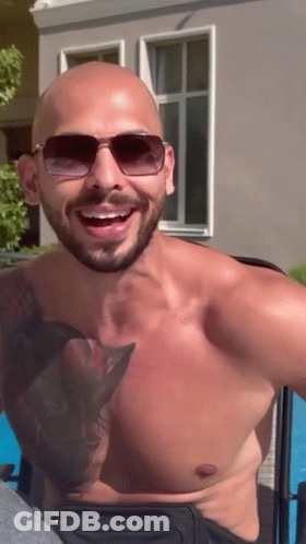 A Shirtless Man With Sunglasses And A Tattoo On His Chest GIF