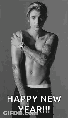 A Shirtless Man With Tattoos On His Arms Is Standing In A Black And White Photo And Wishing A Happy New Year . GIF