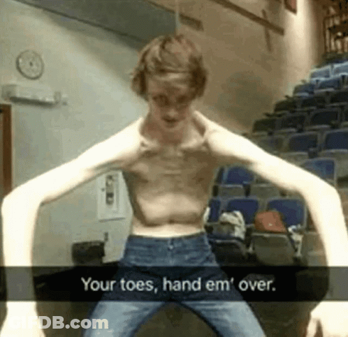 A Shirtless Man With Very Long Arms Is Standing In Front Of A Row Of Blue Seats . GIF