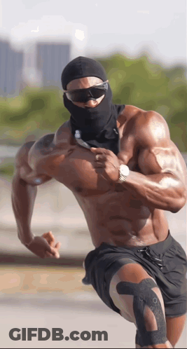 A Shirtless Muscular Man Wearing Sunglasses And A Black Mask Is Running GIF