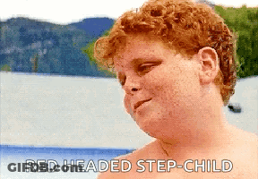 A Shirtless Redheaded Step-Child Is Standing In Front Of A Body Of Water With Mountains In The Background GIF